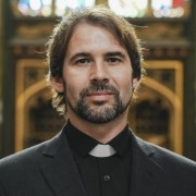 Christian priest standing by the altar